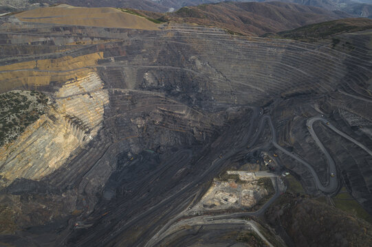 Aerial view of a massive open-pit mine featuring terraced excavation walls and winding access roads in Santa Lucia de Gordon, Castile and Leon, Spain.