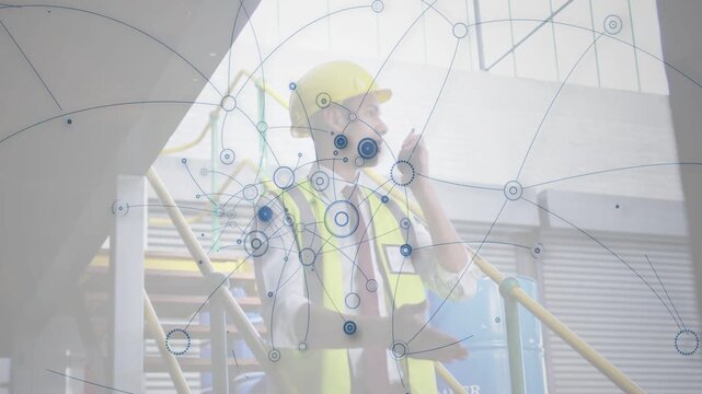 Vertical video: Plant supervisor using radio on stair starting node web around him tracking assets