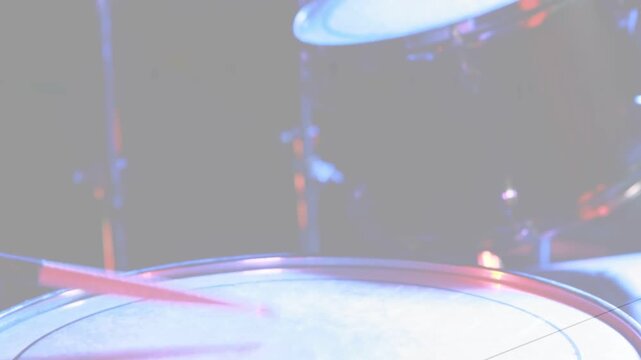 Camera revealing drum head while tom and cymbal reflecting blue magenta lights for music