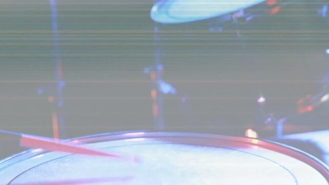 Snare drum head shifting up-right after red stick sweep revealing tom and hardware showing kit