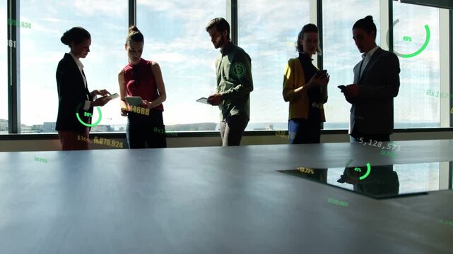 Office team standing by glass man reading tablet stepping closer comparing data HUD moving on table
