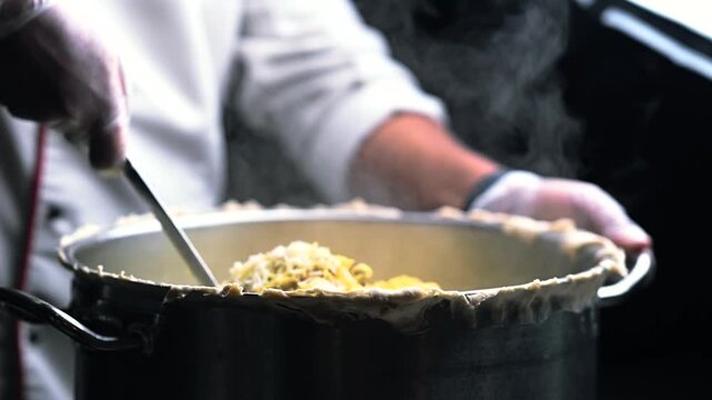 Indian chef cooking Biriyani at the kitchen and adding spices. Spice background 4K video. seasoning in indian food.