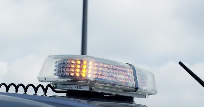 Close up of a transparent led light bar and antenna mounted on the roof of a service vehicle outdoors