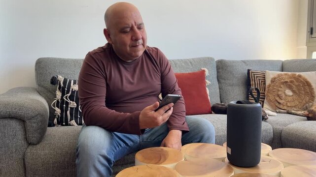 Hombre encendiendo altavoz con m&oacute;vil y bailando