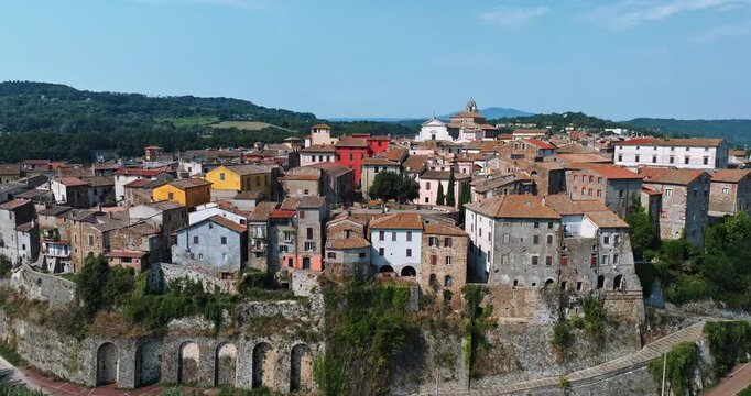Italian village Orte drone view ancient architecture cliffside. Tuff rock formation historic center red roofs green valley landscape summer travel guide commercial stock content.