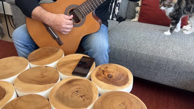 Hombre siguiendo tutorial de guitarra en el m&oacute;vil