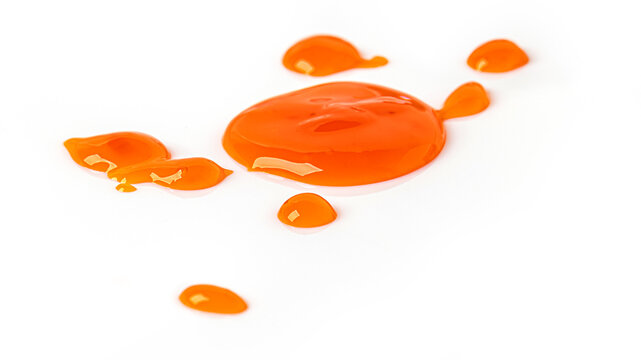 Orange liquid droplets splashing on white background