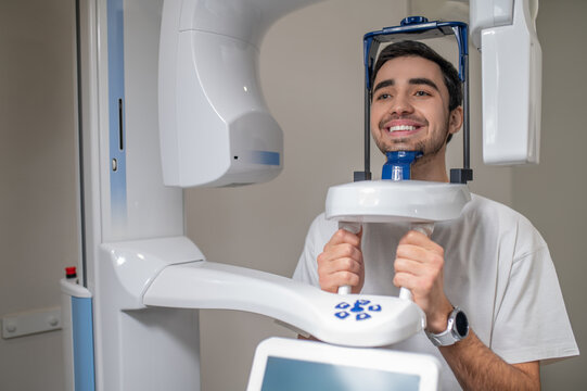 Smiling man undergoing panoramic dental x-ray