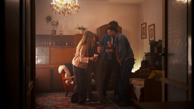 Best friends celebrating together, drinking and having fun at night house party.