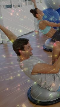 Vertical video: Pair initiating lean-back on cue, performing core reps on dome trainers for balance