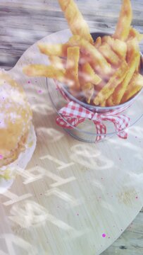 Vertical video: Camera shifting and overlay drifting bringing metal fries bucket to center for shot