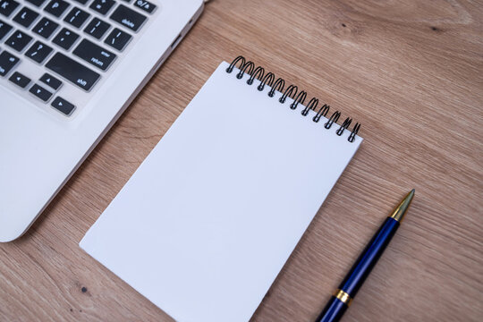 Top View of Blue Calculator Laptop and Blank Notepad with Pen for Office Work and Management