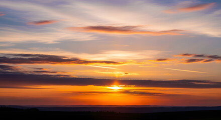 Obraz premium Vibrant sunset with clouds in the sky 