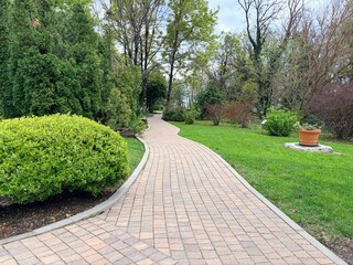 Obraz premium path in the park. Beautiful landscape design. Concrete tiles path in the spring park.