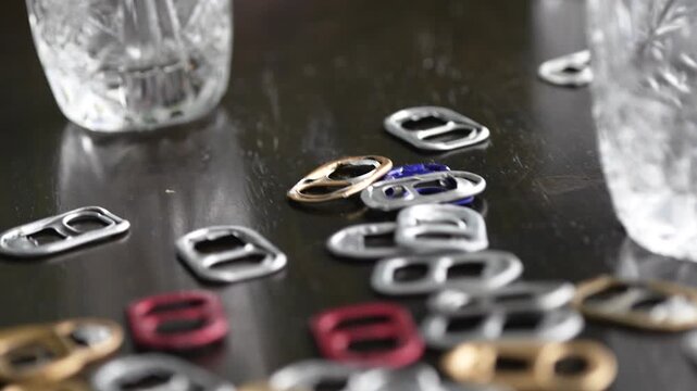 Morning after party with empty shot glasses and metal can tabs scattered on messy table, hangover concept
