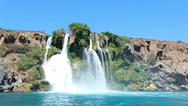 Turkiye, Belek, 27.07.2025 Waterfall in Antalya flows into the Mediterranean sea. Coastal cliff landscape in Turkey during summer vacation. Scenic water destination for travel and holiday.