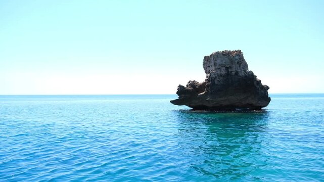 Turkiye, Belek, 27.07.2025 Huge rock formation emerging from clear blue sea water. Tropical travel destination in Turkey. Scenic ocean landscape for summer vacation and leisure tourism trip.