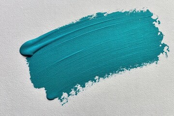 Naklejka premium A textured teal paint stroke across a white textured paper background, abstract artistic brush mark.