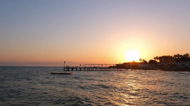 Turkiye, Belek, 27.07.2025 Golden sunset over the Mediterranean sea in Turkey. Seaside vacation resort landscape with pier at dusk. Beautiful tropical beach scenery for summer travel holiday.