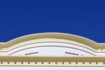 Elegant architectural detail with a curved classical facade against a clear deep blue sky, ideal for urban design, travel themes, and building exterior concepts. © kati17