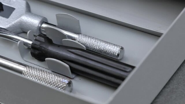 A set of tools for threading in a metal case.
