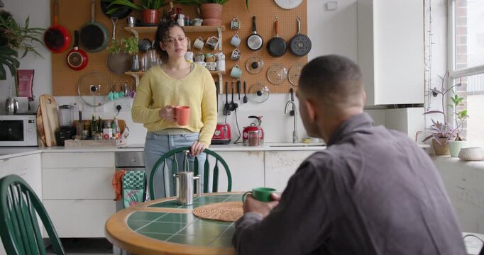 Young couple chatting over coffee in a kitchen