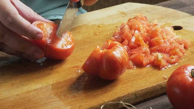 A woman's hands cut fresh tomatoes with a knife
