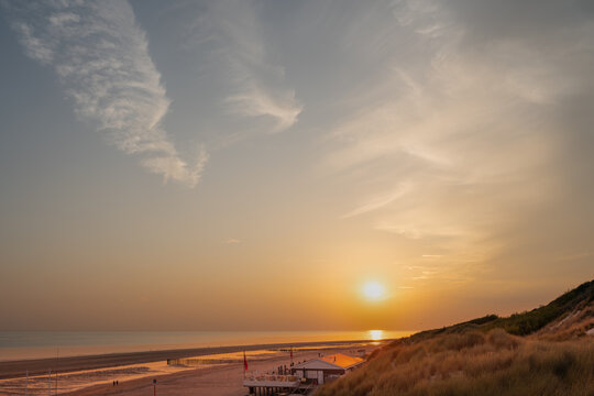 North Sea, dune, Zeeland province &ndash; people walk on the beach and watch the sunset