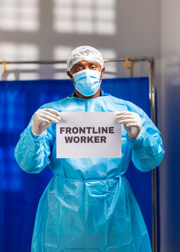African male doctor wearing ppe and mask, standing ready to work on hospital frontline