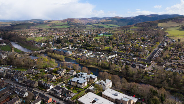 High angle aerial view of the historic town of Peebles nestled in the lush green valley of the River Tweed, Scottish Borders, Scotland. Scenic landscape featuring traditional stone architecture, river