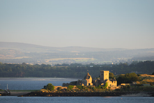 Golden hour summer evening view of the historic Incholm Abbey on the Firth of Forth as seen from Aberdour, Fife, Scotland, UK.