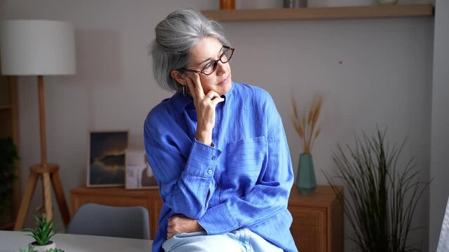 Thoughtful mature businesswoman thinking and planning at home office