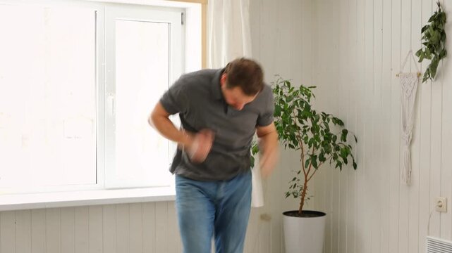 Handsome bearded man dance, have fun at home listens song, moves to music, feels overjoyed, celebrate good news, relish carefree life looks happy. Young adult male twirls, grooves, dancing in kitchen