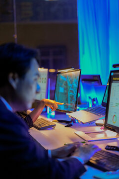 Expert AI engineer monitoring real time data dashboards and predictive analytics in a futuristic SOC. Professional specialist evaluating neural network performance during late night security shift.