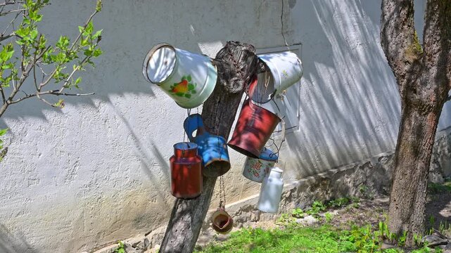 Vintage Enamel Buckets and Milk Cans on a Wooden Post
