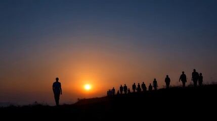 Fototapeta premium A group of people stands in silhouette on a high hill overlooking the vast landscape at sunrise or sunset