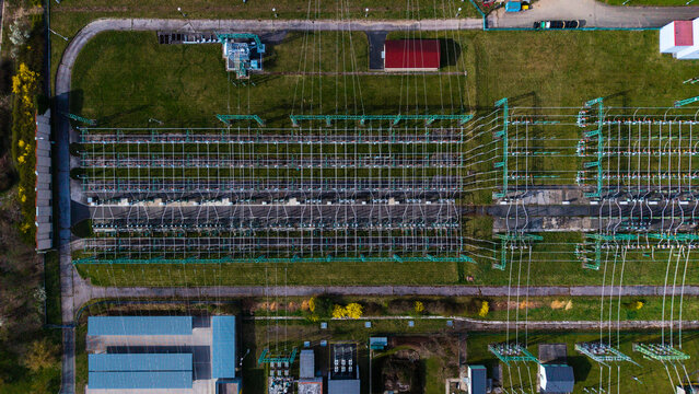Aerial view of an electrical substation with a network of cables and equipment contrasting with the surrounding green grass, Praha-Seberov, Hlavni mesto Praha, Czechia.