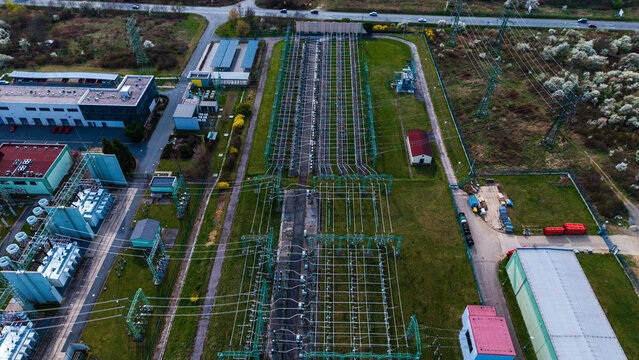 Aerial view of the electric substation, a network of power lines, and the adjacent building contrasting with the surrounding greenery, Praha-Seberov, Hlavni mesto Praha, Czechia.