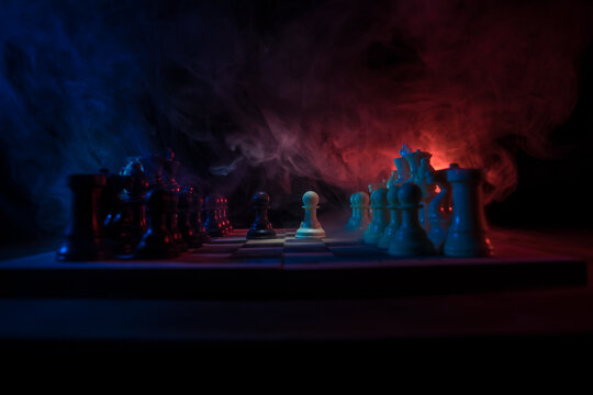Chess board game concept of business ideas and competition. Chess figures on a dark background with smoke and fog.