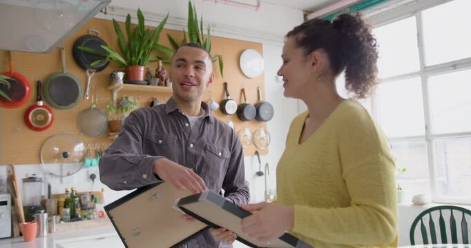 Couple deciding where to hang pictures in their new home