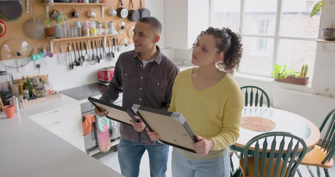 Couple deciding where to hang pictures in their new home