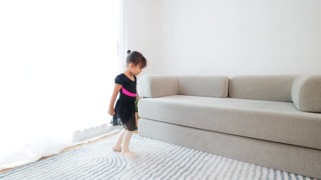 Happy latin little girl dancing ballet at home in ballerina dress - Childhood activity concept