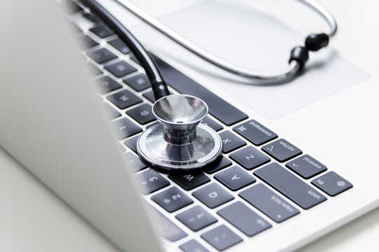 Stethoscope on laptop keyboard close up showing digital healthcare concept