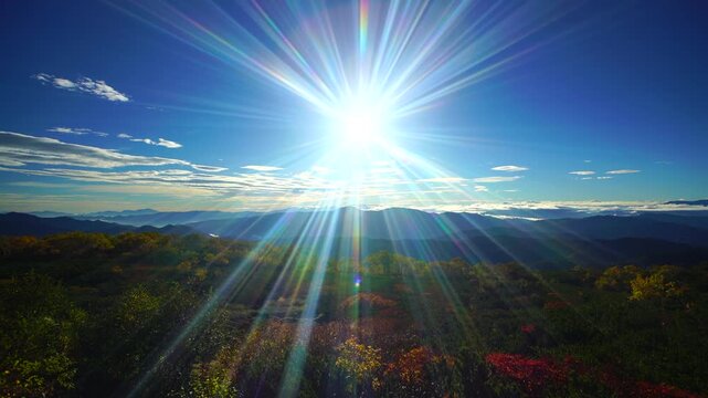 乗鞍岳位ヶ原の紅葉と八ケ岳方向の山並みと朝の太陽の光芒