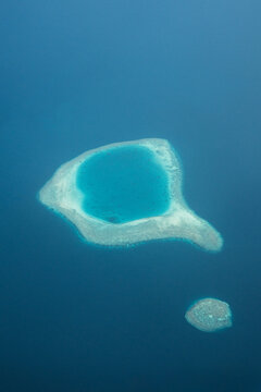 Aerial view of a tranquil island lagoon, a jewel of turquoise embraced by the vast cerulean sea, Flight from Male to Hanimaadhoo island, Maldives.