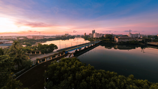 Aerial view of the bridge reflecting the pastel sky above the tranquil river, embracing the buildings of the city, Iloilo City, Western Visayas, Philippines.