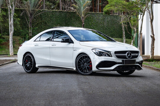 White Mercedes CLA 45 AMG front three quarters view, Premium compact sports sedan in park setting