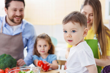 Obraz premium Happy family cooking together at table in kitchen, selective focus