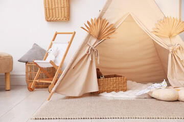Stylish wigwam with dry leaves in child's room © New Africa