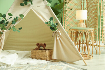 Cute wigwam with leaves and blanket in stylish child's room © New Africa